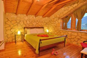 a bedroom with a bed and a stone wall at Villa Tireda in Keri +15 photos