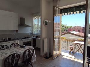 een keuken met een tafel en uitzicht op een balkon bij Intero Appartamento a soli 50 m dal mare in Viareggio