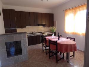 een keuken met een tafel met stoelen en een open haard bij Apartment Deni - 70m from beach in Milna