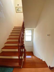 - un escalier dans une maison dotée de parquet et d'une fenêtre dans l'établissement Azumaya guest house, à Magong