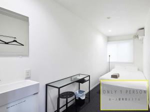 a white room with a bed and a sink at RAK KIYOMIZU - 1人旅専用hostel in Kyoto