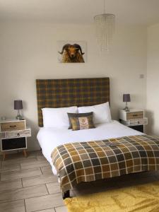 a bedroom with a bed with a cow on the wall at The Lambing Shed in Dunvegan