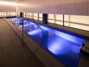 una piscina con luces azules en un edificio en Hotel Intergate Osaka Umeda, en Osaka