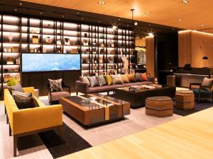 a living room with couches and a large screen at Hotel Intergate Osaka Umeda in Osaka