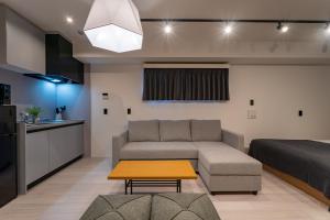 een woonkamer met een bank, een bed en een tafel bij STAY IN YEBISU in Osaka