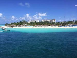 a view of a beach with a boat in the water at Hotel Bucaneros Isla Mujeres in Isla Mujeres