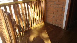 a balcony with a wooden railing and a brick wall at O Chalé de Rita in Lima Duarte