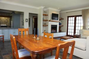 a living room with a wooden table and chairs at Fynbos Ridge Country House & Cottages in Plettenberg Bay