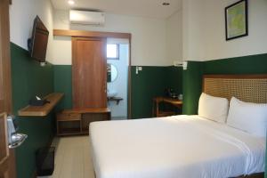 Uma cama ou camas num quarto em Liberta Malioboro South