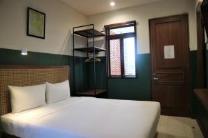 Uma cama ou camas num quarto em Liberta Malioboro South