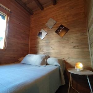 1 dormitorio con 1 cama en una pared de madera en Guané Glamping & Ecolodge - Oriente Antioquia, en Guarne