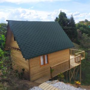 a small wooden house with a black roof at Guané Glamping & Ecolodge - Oriente Antioquia in Guarne