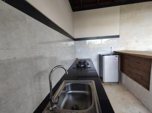 a kitchen with a sink and a stove at Anggarakasih Ubud Villa in Ubud