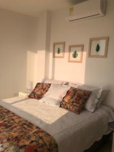 een slaapkamer met een groot bed met kussens erop bij NUEVO PRECIOSO APARTAMENTO in Cartagena