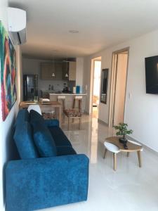 een woonkamer met een blauwe bank en een keuken bij NUEVO PRECIOSO APARTAMENTO in Cartagena
