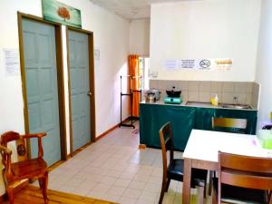 a kitchen with blue doors and a table and chairs at Soboroong Farmer's Cottage in Kampong Kundassan