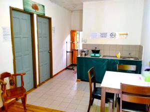 a kitchen with blue doors and a table and chairs at Soboroong Farmer's Cottage in Kundasang