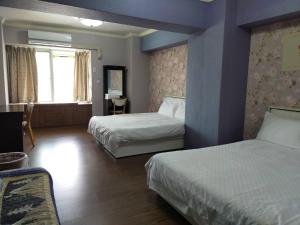 花蓮市的住宿－柚子之家和平民宿，酒店客房设有两张床和窗户。