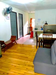 a living room with a couch and a table and a kitchen at Soboroong Farmer's Cottage in Kundasang