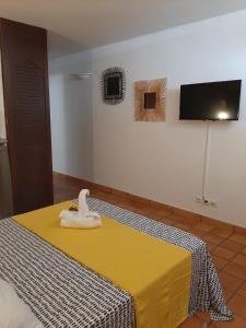 a yellow bed with a white object on top of it at Charmant studio à la Résidence de la Baie de Tartane in La Trinité