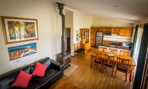 a living room with a couch and a dining room at Cottages on Lovedale - Cottage No. 2 in Lovedale