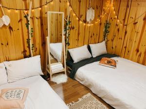 a bedroom with two beds and a mirror and lights at EUDORA HOUSE 2 in Da Thien