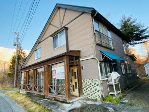 ein kleines Haus mit einer Veranda und einem Fenster in der Unterkunft 2nd House Family in Akimoto