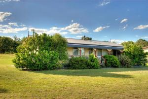 a house with bushes in front of a yard at Cottages on Lovedale - Cottage No. 3 in Lovedale