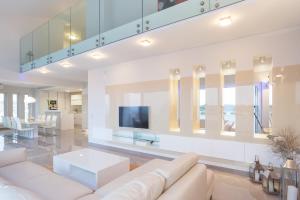 a living room with a white couch and a tv at Apartments Lofiel in Novalja
