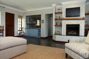 a living room with a couch and a fireplace at Fynbos Ridge Country House & Cottages in Plettenberg Bay