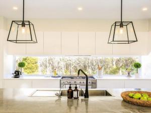 a kitchen with a sink and a stove and a window at Amaroo in Bowral