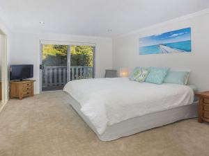 a bedroom with a large bed and a television at Retreat on Manning- Kiama in Kiama