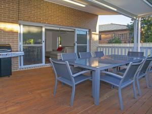 a patio with a table and chairs on a deck at Retreat on Manning- Kiama in Kiama