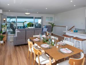 een eetkamer en een woonkamer met een tafel en stoelen bij Blue Pelican in Kiama Downs