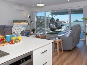 een keuken en een woonkamer met uitzicht op de oceaan bij Blue Pelican in Kiama Downs