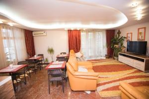 a living room with a couch and a television and tables at Home Sweet Home in Chişinău