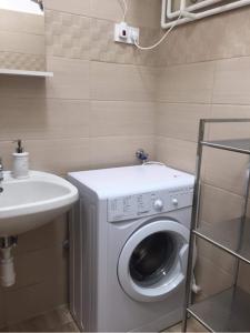 a bathroom with a washing machine and a sink at Bremi Apartman Fonyódliget in Fonyód