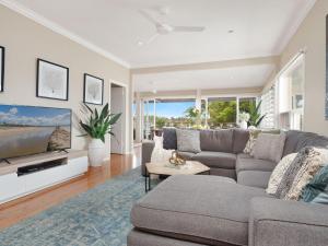a living room with a couch and a flat screen tv at The Old Bottleshop in Currarong