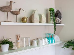 a shelf with vases and birds on it at The Old Bottleshop in Currarong