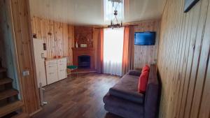 Una sala de estar con un sofá y un televisor en la pared. en Дача у моря, en Odessa 9 fotos más