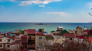 un grupo de edificios con un barco en el agua en Дача у моря, en Odessa