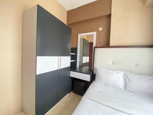 a bedroom with a bed and a mirror on the wall at Comfy & Well Appointed 2BR at Tamansari Panoramic Apartment By Travelio in Bandung +12 photos
