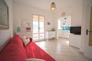 un soggiorno con divano rosso e una cucina di Villa Manzoni a Campese