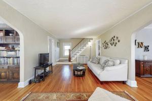 a living room with a white couch and a staircase at Belltown Retreat in Stamford