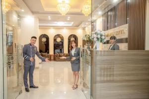 um homem e uma mulher apertando as mãos numa loja em MOMALI Hotel Ninh Binh em Ninh Binh