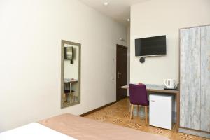 a hotel room with a desk and a purple chair at Yerevan Boutique Hotel in Yerevan