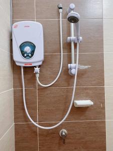 um dispositivo branco na parede de uma casa de banho em Desaru KTV Natural wood style by Joyfully 31A7 em Desaru
