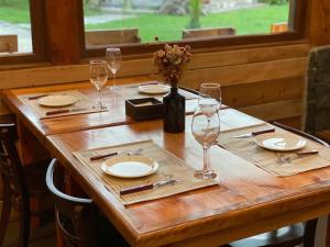 a wooden table with plates and wine glasses on it at Terra Volcán in Victoria