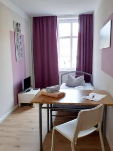 Zimmer mit einem Tisch, einem Bett und einem Fenster in der Unterkunft Pension BERLIN in Spremberg in Spremberg