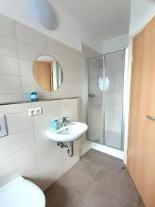 W łazience znajduje się umywalka i prysznic. w obiekcie Pension BERLIN in Spremberg w mieście Spremberg